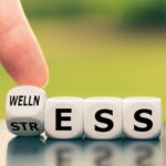 dice spelling the words wellness and stress, stress and oral health
